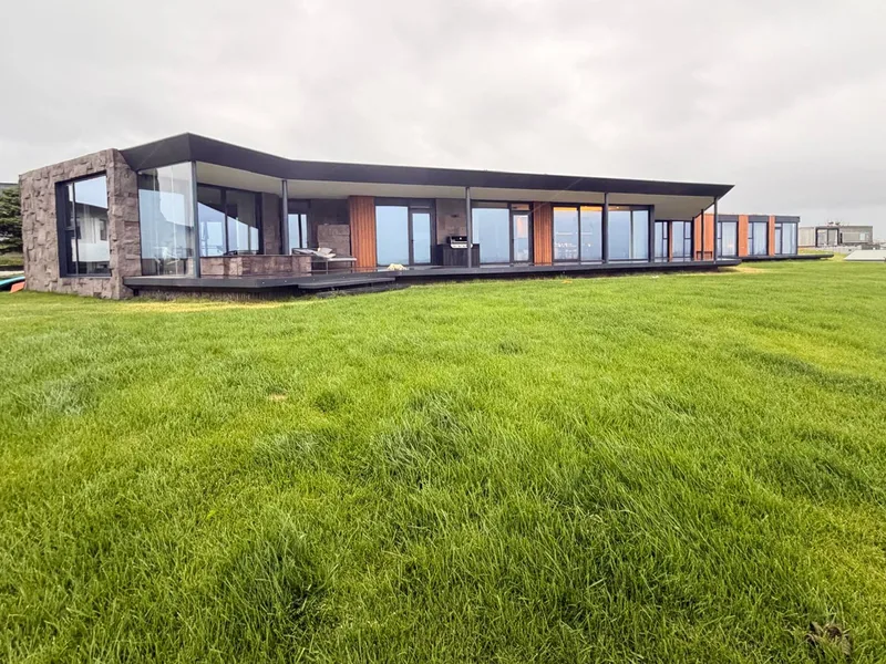 Lágreist einbýlishús með Western Red Cedar, náttúrusteini og glerhliðum á grasflöt