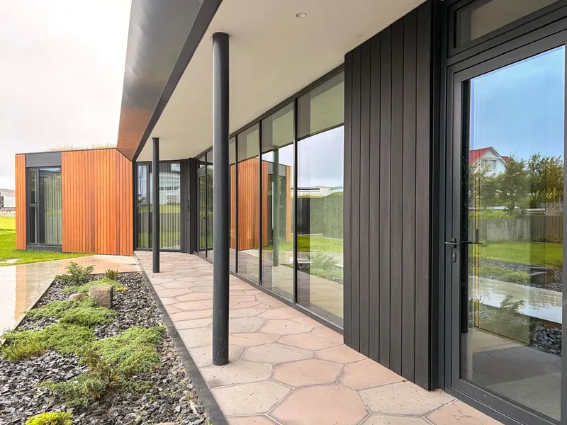 Yfirbyggður gangur meðfram glerhlið, með Western Red Cedar klæðningu í enda